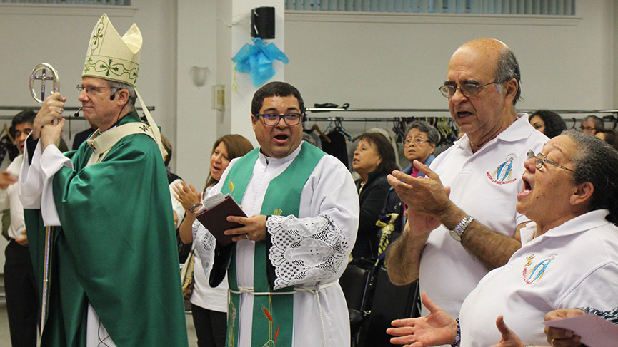 Mgr Lépine, le père Clecio et l'assemblée en prière.