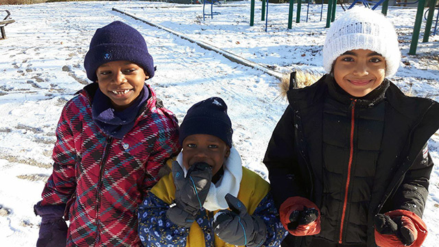 Des enfants résidents au Centre Le Pont jouent dehors.