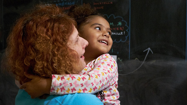 Alessandra Santopadre, holding a young resident of the Asylum seeker Center "Le Pont" in Montreal.