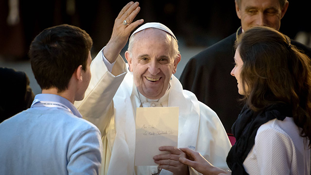 Le pape François en compagnie de deux jeunes