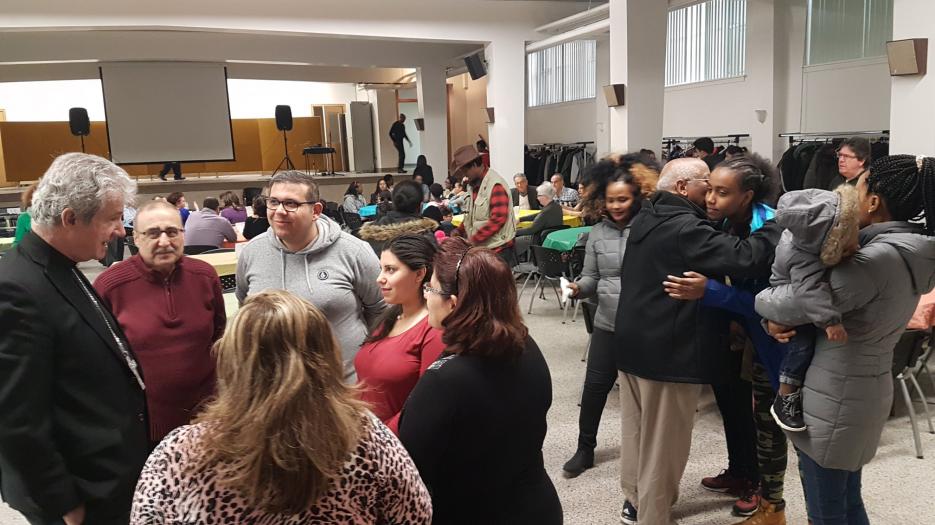 Msgr. Lépine welcoming one refugee family from Syria.