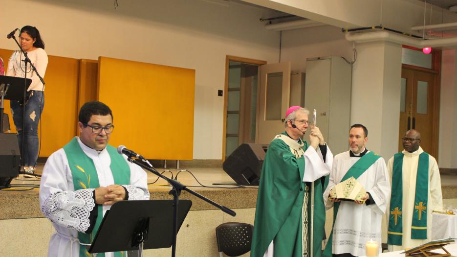 Le Père Clecio proclamant l’Evangile (Photo : Isabelle de Chateauvieux) - © Église catholique à Montréal