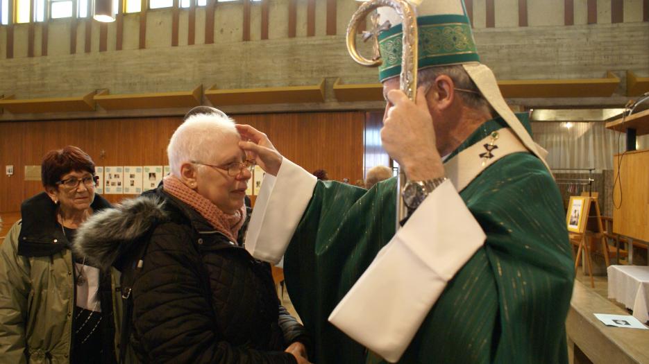 As usual, Most Rev. Lépine meets all the parishioners after each Mass and takes the time to pray with them and for them. (Photo : Brigitte Bédard)